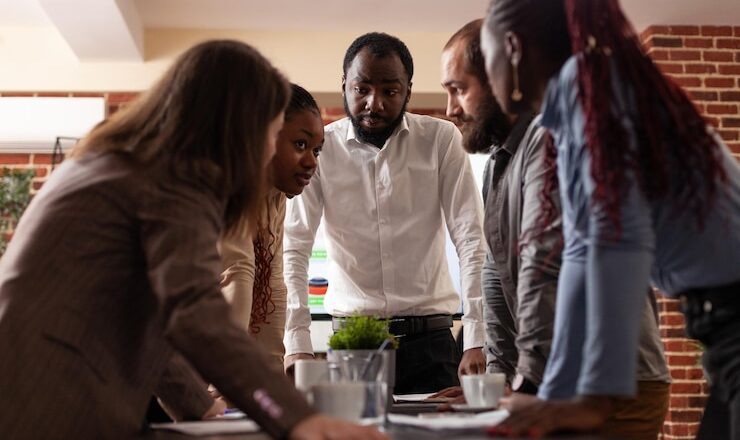 multi-ethnic-entrepreneurs-stand-up-analyzing-financial-graph-brainstorming-ideas-partnership-project-working-company-presentation-startup-office-execut